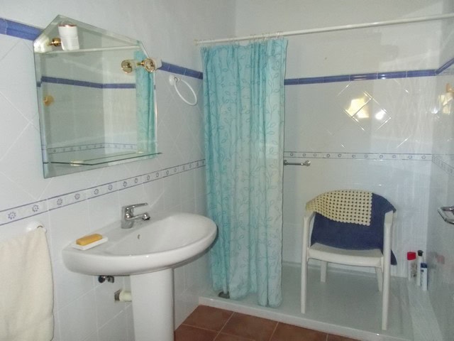 Cozy bathroom in a village property located in Tijola, Almeria, featuring a shower, sink, and simple.