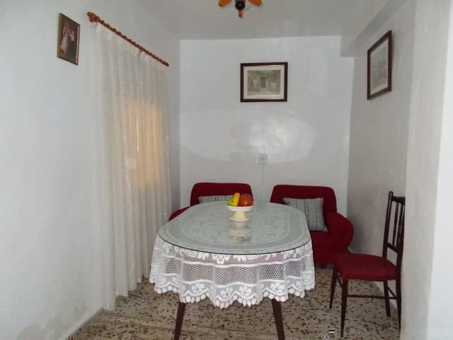 Village property interior with dining area in Zujar, Granada, featuring simple furnishings and cozy.
