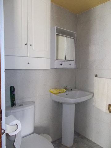 Cozy bathroom in a village property in Zujar, Granada, featuring a white sink, mirror, and basic ame.
