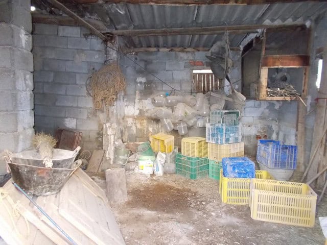 Spacious interior of a village property in Zujar, Granada, showing storage area with crates and cons.