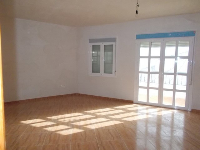 Spacious living room with large windows and natural sunlight in Lucar, Almeria.