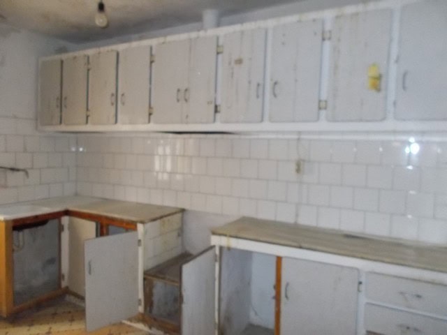 Charming town house interior in Tijola, Almeria, with white cabinets and tiled walls, ideal for reno.