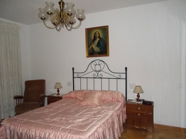 Charming bedroom in a village property in Seron, Almeria, featuring a wrought iron bed and classic d.