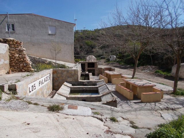 Fountain and outdoor seating in Hijate village, Almeria, Spain. Traditional rural setting with stone.