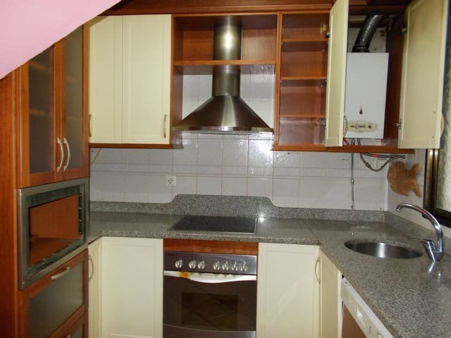 Modern kitchen in Tijola town house, Almeria with stainless steel appliances and ample storage space.