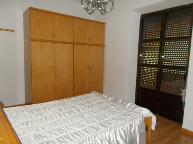 Charming bedroom in Tijola town house with wooden wardrobe and natural light.