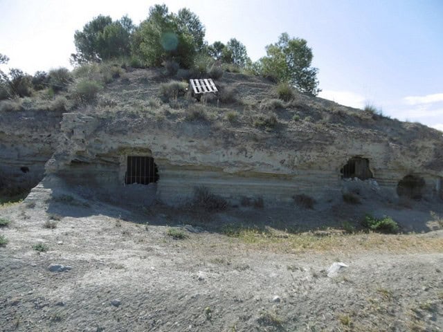 Cave house built into the rocky hillside in Benamaurel, Granada, offering a unique living experience.