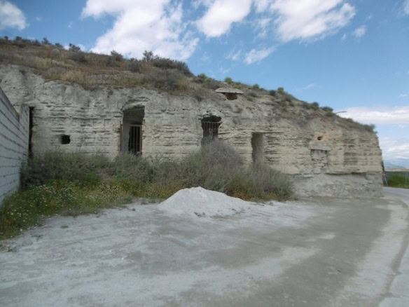 Ancient cave house carved into rocky hillside in Benamaurel, Granada, offering unique rustic living.