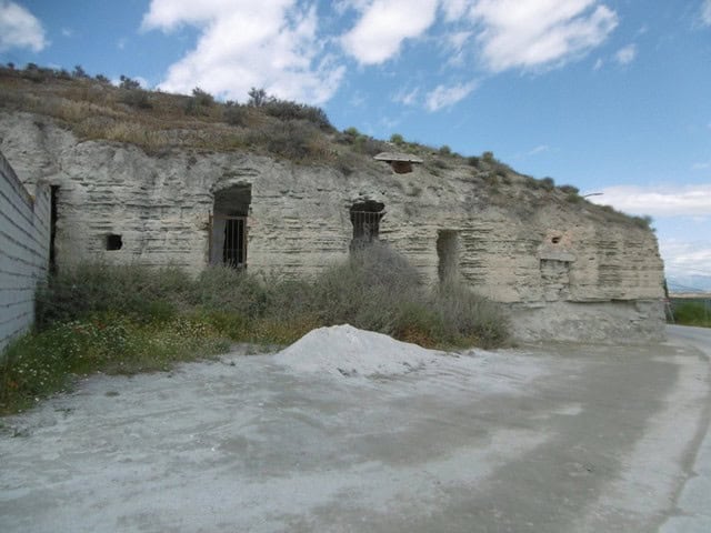 Ancient cave house carved into rocky hillside in Benamaurel, Granada, offering unique rustic living.