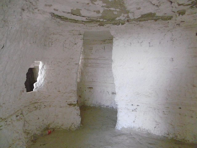 Cave house interior in Benamaurel, Granada, showcasing traditional whitewashed walls and rustic char.