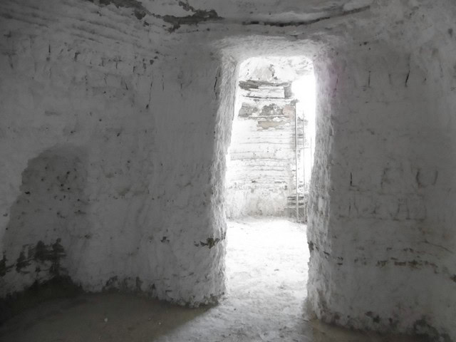 Cave house interior in Benamaurel, Granada, showcasing traditional whitewashed walls and rustic char.