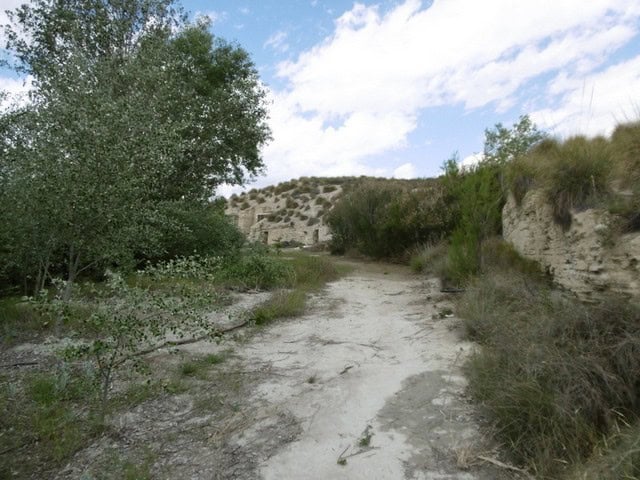 Cave house located in Benamaurel, Granada, surrounded by natural landscape and rugged terrain.