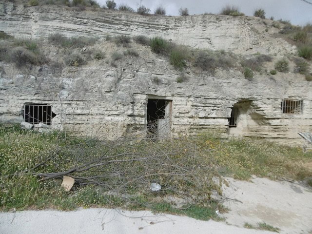 Cave house in Benamaurel, Granada, built into natural rock with small windows and entrance.