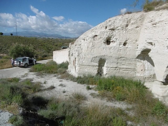 Unique cave house in Benamaurel, Granada, carved into natural rock with small windows and a rustic e.