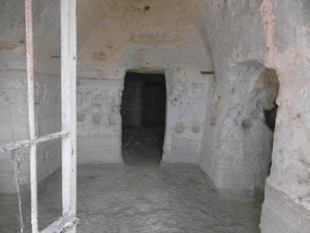Ancient cave house interior in Benamaurel, Granada, showcasing natural rock walls and unique archite.