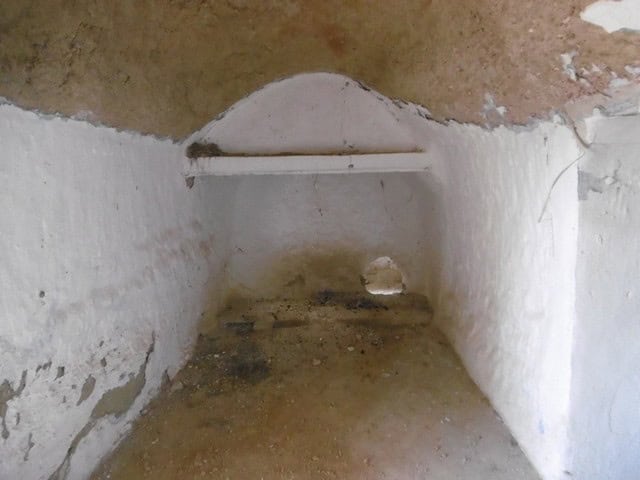 Unique cave dwelling in Benamaurel, Granada, with rustic interior and natural stone walls.