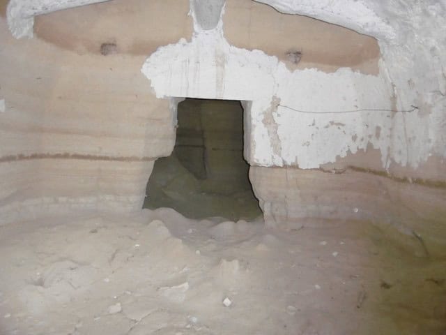 Underground cave house in Benamaurel, Granada, with natural rock walls and a small entrance.