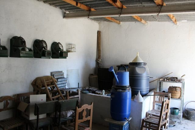 Interior of rural property with water tanks and wooden furniture in Lucar, Almeria.