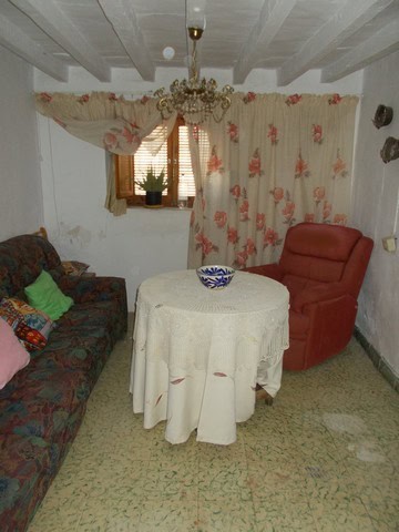 Charming living room of a town house in Seron, Almeria, featuring vintage furniture, floral curtains.