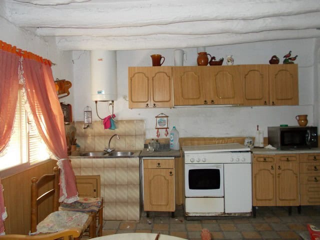 Charming kitchen of a town house in Seron, Almeria, featuring rustic wooden cabinets and traditional.