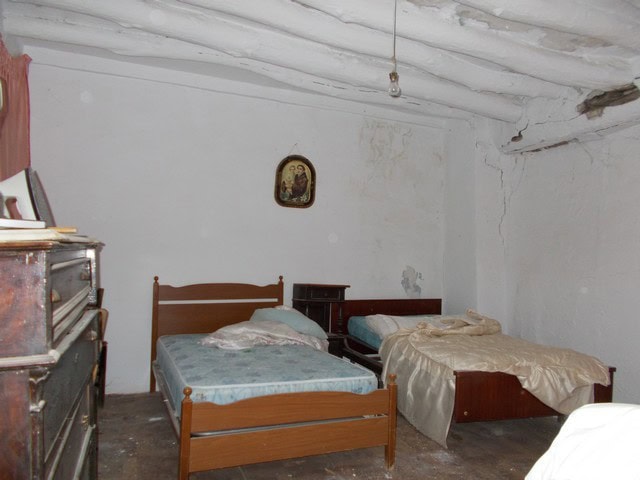 Interior of a rustic town house bedroom in Seron, Almeria with two beds and vintage furniture.