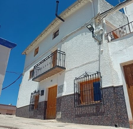 Charming village house in Hinojares, Jaen featuring white walls, wooden doors, and cozy balconies.