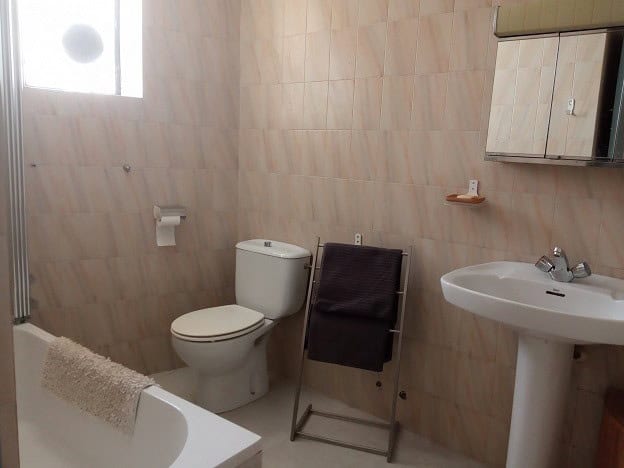 Cozy bathroom in a village property in Hinojares, Jaen, featuring a toilet, sink, and simple decor.
