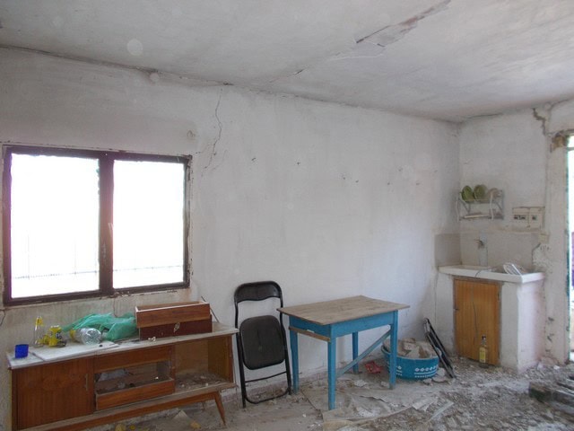 Rural property interior with unfinished walls, window, and basic furniture in Tijola, Almeria.