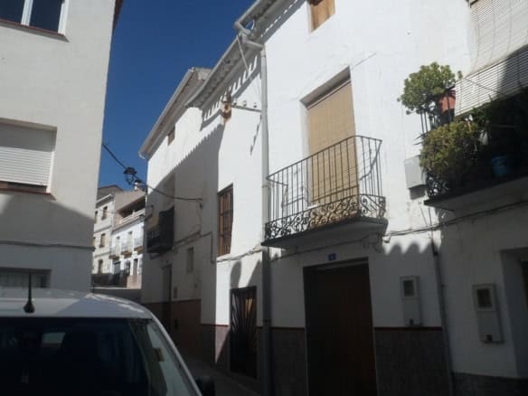 Charming village house in Cullar, Granada featuring white walls and cozy balconies.