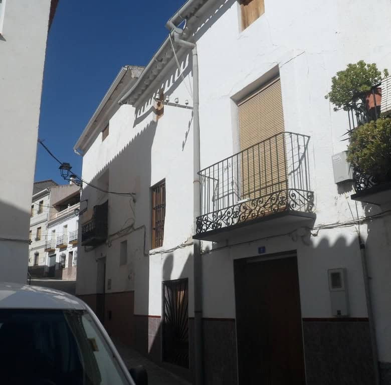 Charming village house in Cullar, Granada featuring white walls and cozy balconies.
