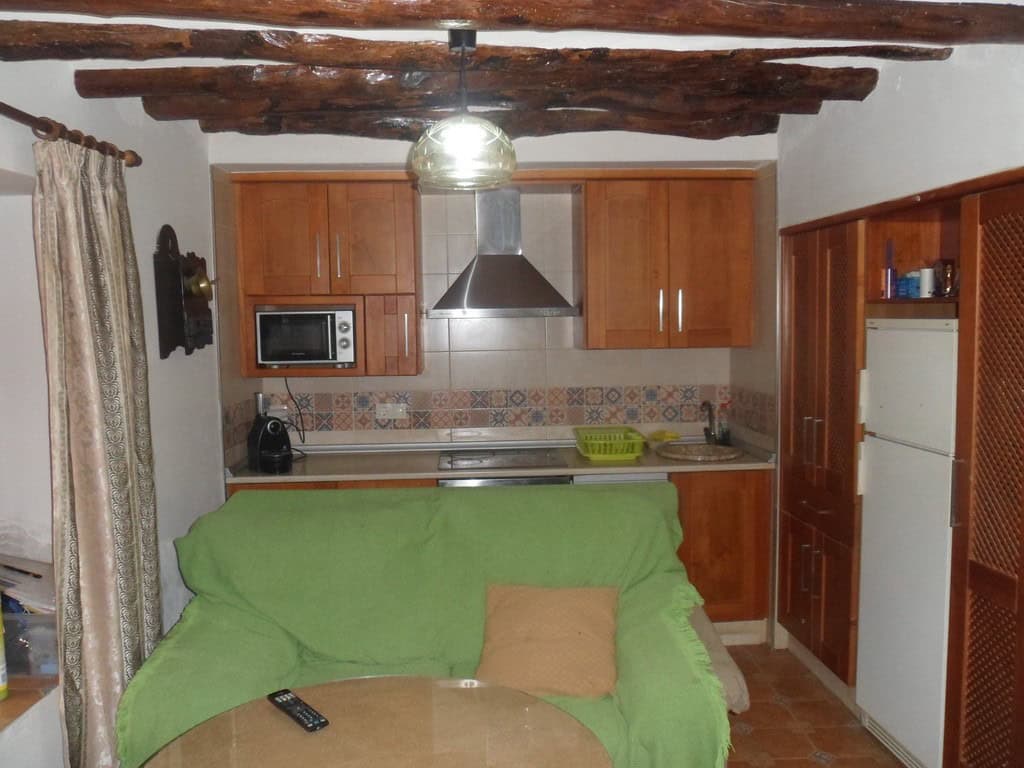 Charming village home in Cullar, Granada with a cozy kitchen and rustic wooden ceiling beams.