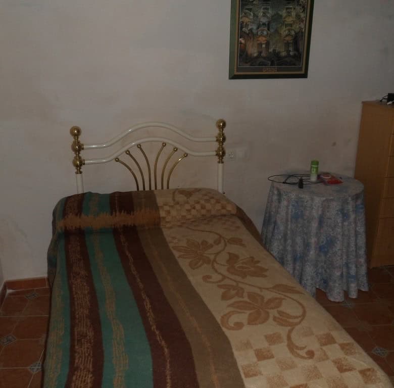 Village Property Bedroom in Cullar, Granada with simple furnishings and rustic charm.