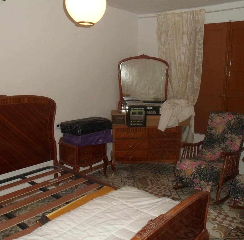 Charming bedroom in a village property in Cullar, Granada, featuring vintage furniture and tradition.