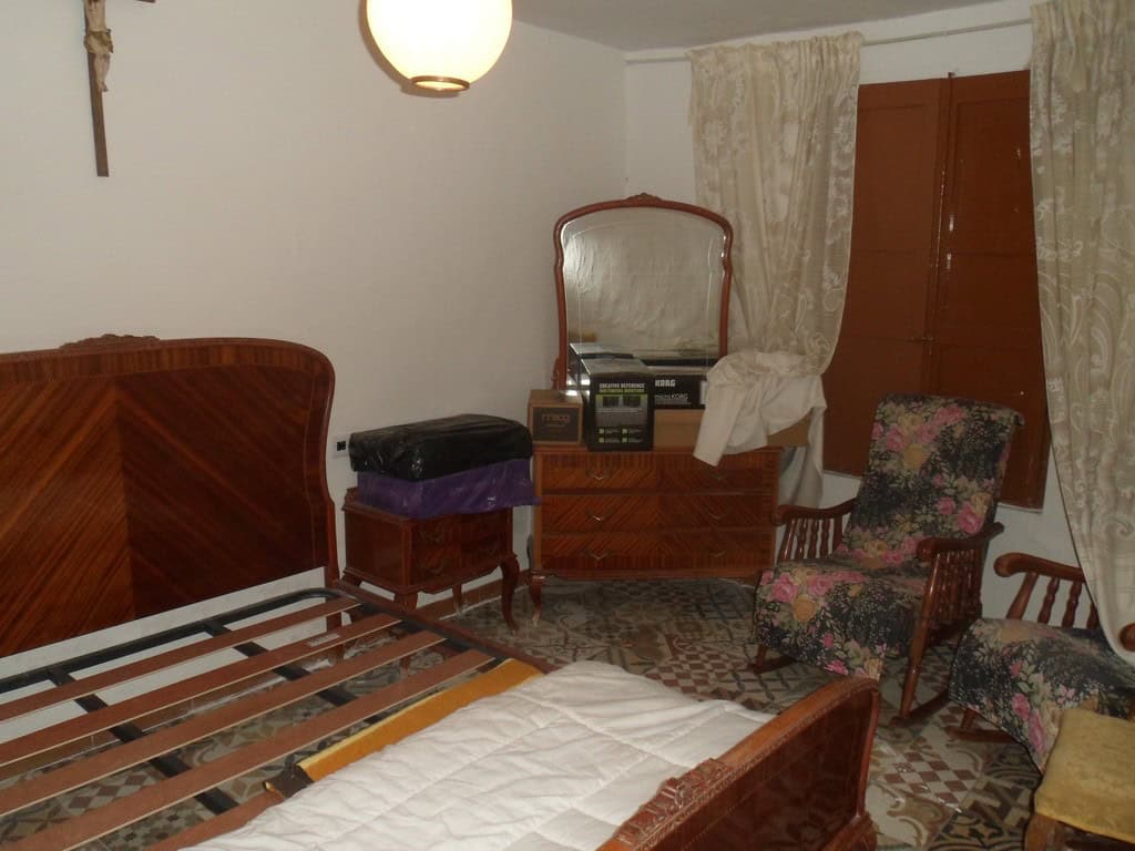 Charming bedroom in a village property in Cullar, Granada, featuring vintage furniture and tradition.