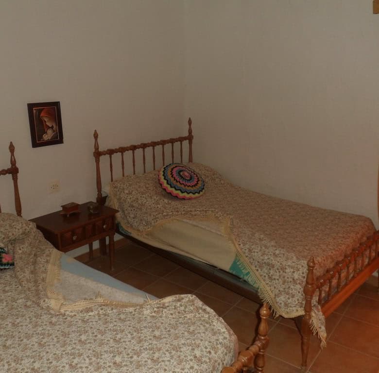 Village property bedroom with two single beds and traditional decor.