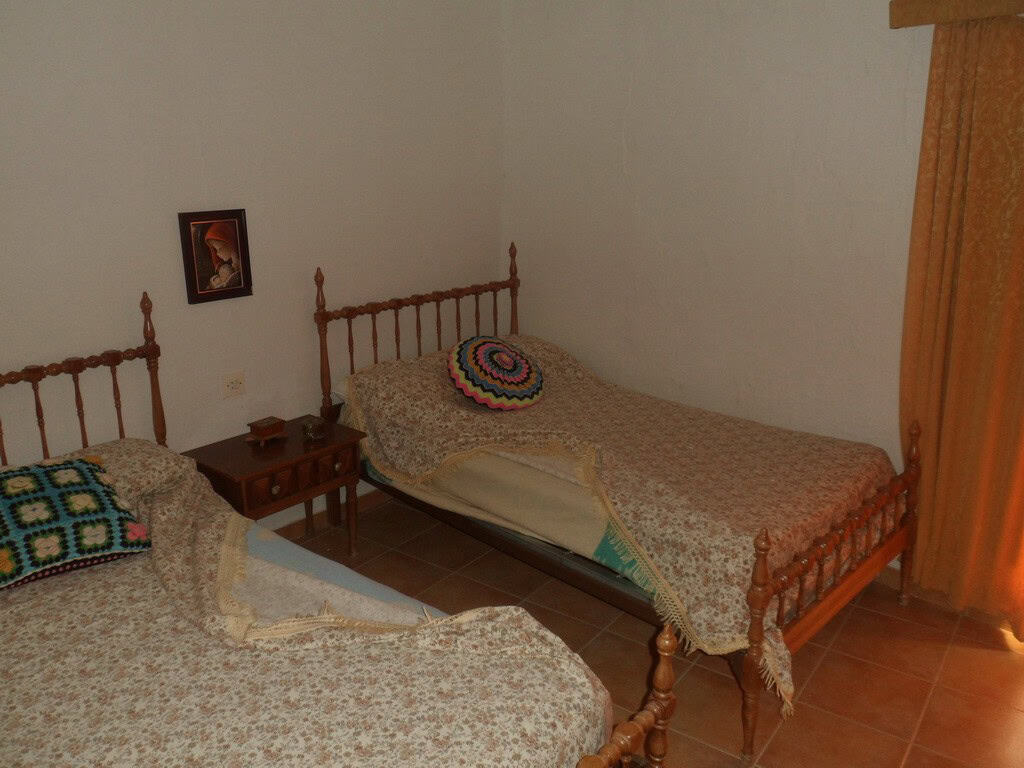 Village property bedroom with two single beds and traditional decor.