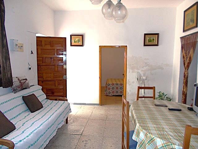 Charming village house interior in Hijate, Almeria, featuring a simple living area, dining table, an.