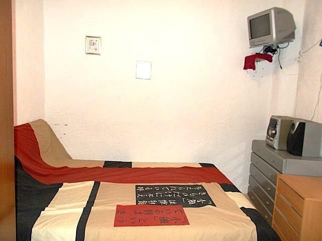 Charming village property in Hijate, Almeria, featuring a simple interior with a bed, small TV, and.