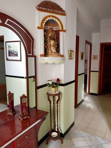 Charming interior of a town house in Cullar, Granada with traditional decor and religious shrine.