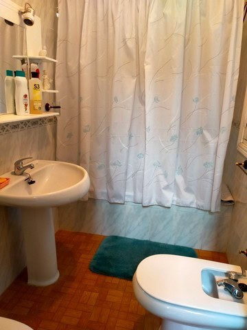 Charming bathroom in a town house located in Cullar, Granada, featuring a sink, bidet, and shower wi.