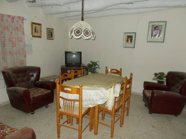Vintage rural living room in Bayarque, Almeria with wooden dining table and classic armchairs.