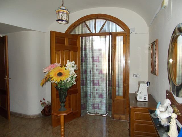 Beautiful town house entrance in Cullar, Granada with wooden door and floral decor.