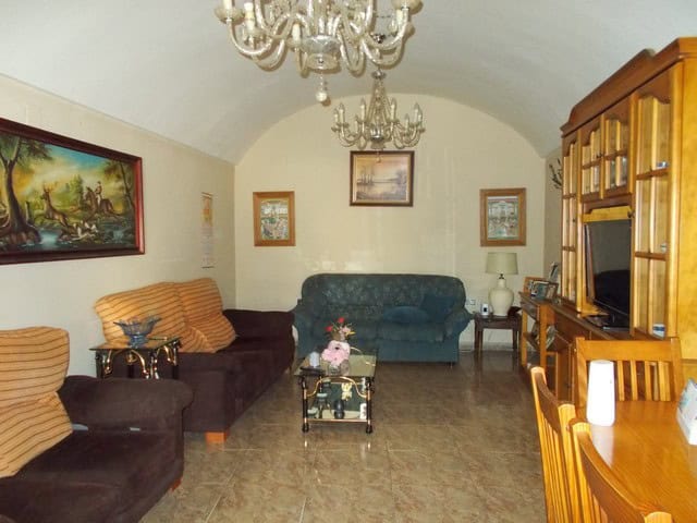 Charming town house living room in Cullar, Granada with vintage furniture and elegant chandelier.