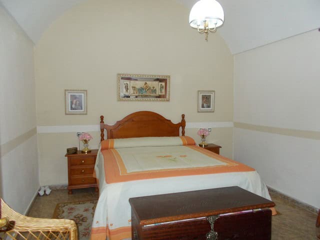 Charming town house bedroom in Cullar, Granada with traditional decor and cozy ambiance.