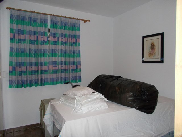 Spacious bedroom with colorful curtains and a large bed, located in a rural property in Caniles, Gra.