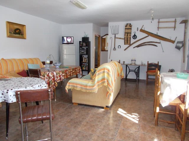 Interior of rural property in Caniles, Granada with traditional decor and vintage tools on the wall.