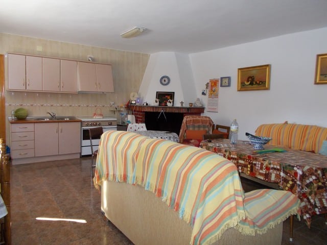 Interior of a rural property living space in Caniles, Granada, featuring a fireplace, colorful furni.