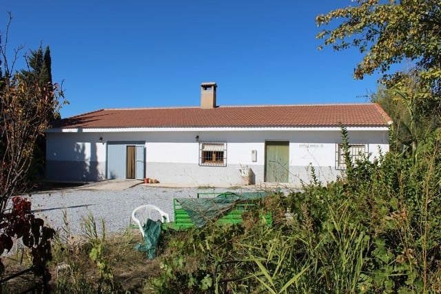 Rural property for sale in Caniles, Granada, featuring a traditional single-story house with a spaci.