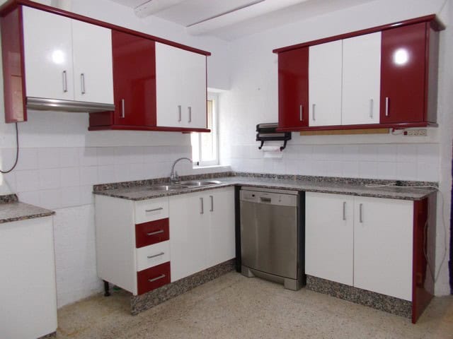 Charming kitchen in a village property in Cela, Almeria, featuring modern white and red cabinets and.