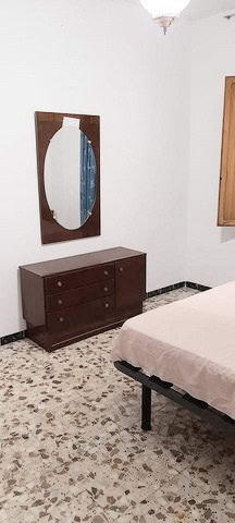 Cozy bedroom in Zujar, Granada with minimalist decor and wooden accents.